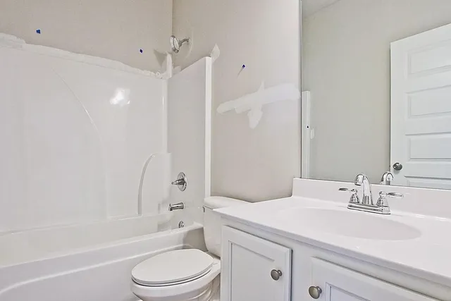 a bathroom with a sink toilet vanity and shower