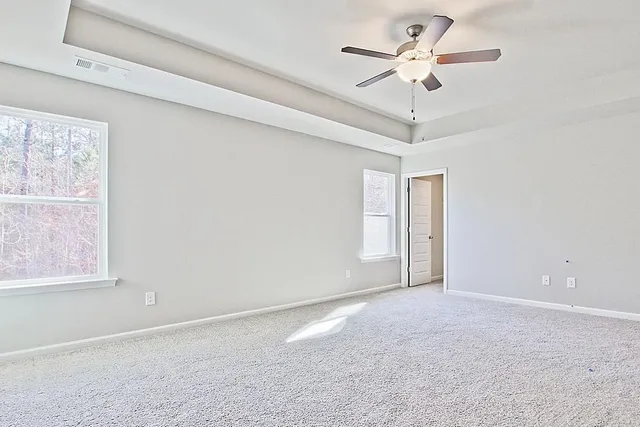 a view of an empty room with a ceiling fan and a window