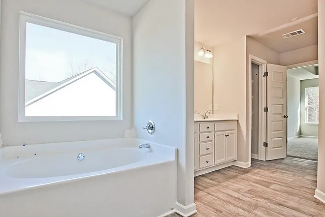 a spacious bathroom with a tub shower and a sink