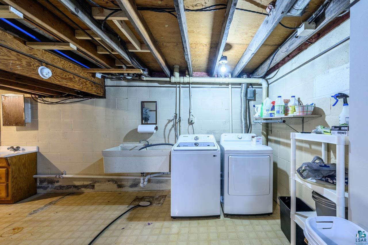 2581 O'Rourke Road Hibbing, MN 55746 - Photo 29 of 61 Laundry area with concrete block walls, exposed ceiling joists, and utility sink