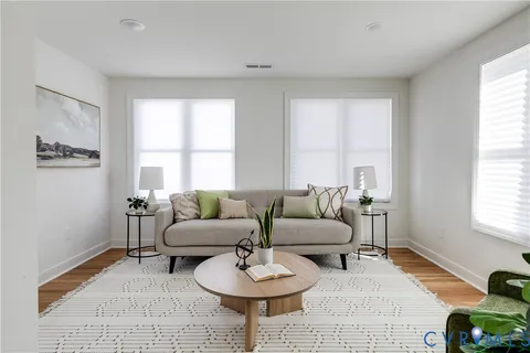 a living room with furniture and a wooden floor
