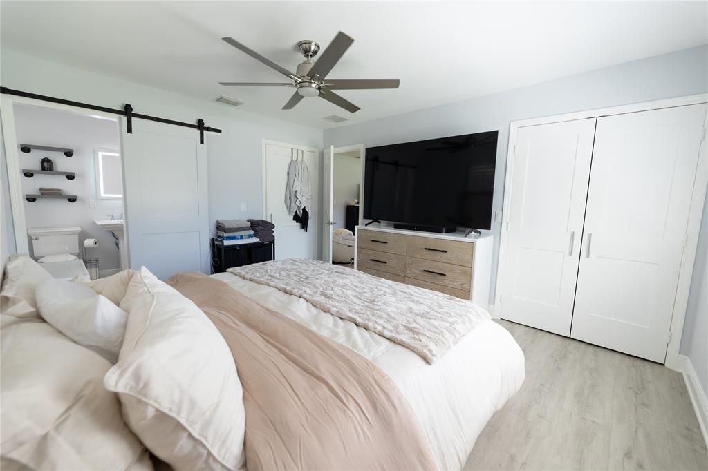 1497 Southwest Buckskin Trail Stuart, FL 34997 - Photo 14 of 48 a bedroom with a bed and a flat screen tv