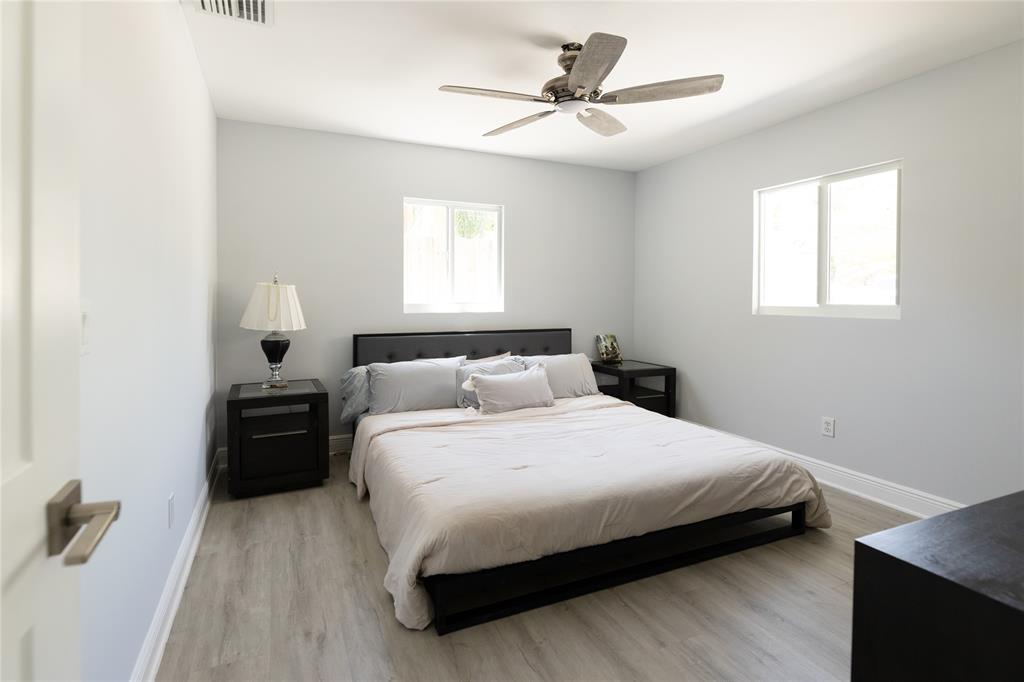 1497 Southwest Buckskin Trail Stuart, FL 34997 - Photo 19 of 48 a bedroom with a bed and a chandelier