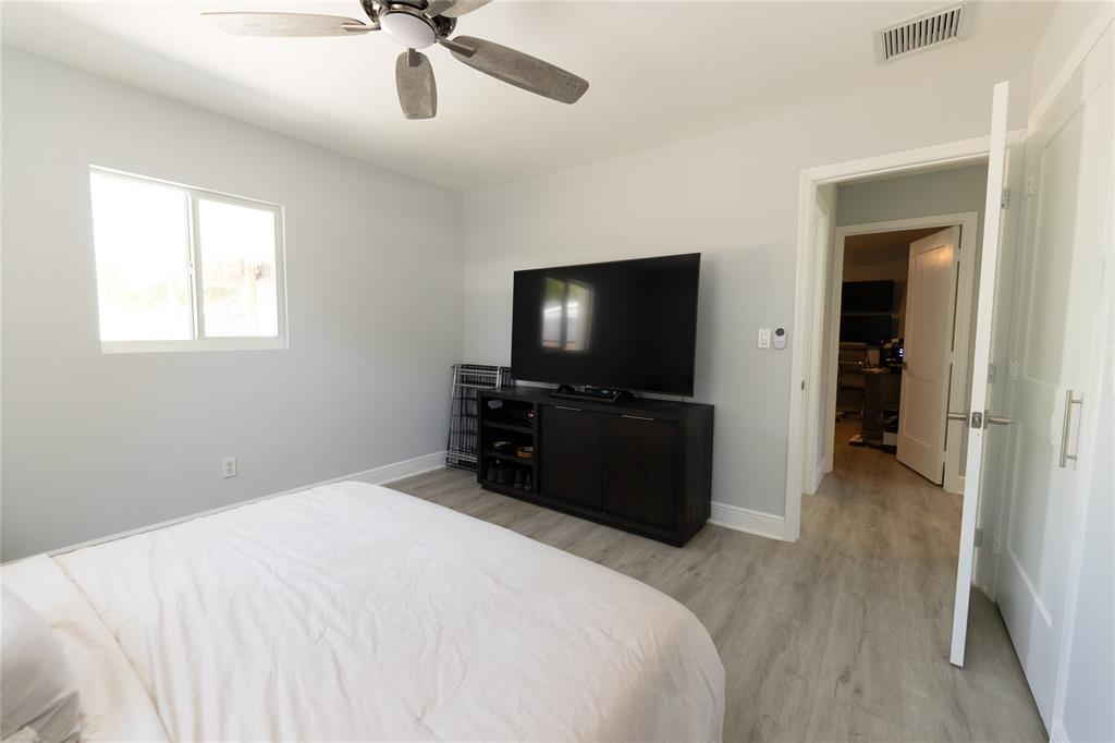 1497 Southwest Buckskin Trail Stuart, FL 34997 - Photo 22 of 48 a bedroom with a bed and a flat screen tv