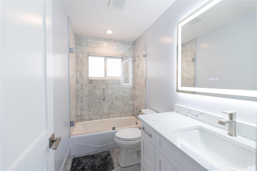 1497 Southwest Buckskin Trail Stuart, FL 34997 - Photo 23 of 48 a bathroom with a granite countertop toilet a sink and bathtub