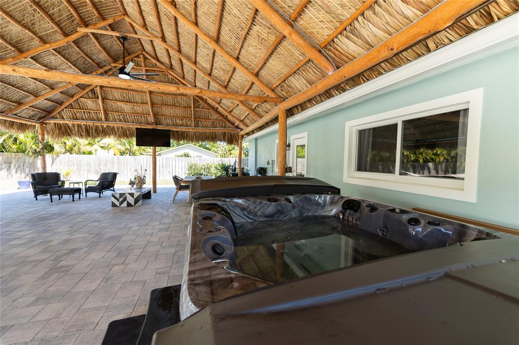 1497 Southwest Buckskin Trail Stuart, FL 34997 - Photo 34 of 48 a view of a patio with table and chairs with wooden fence