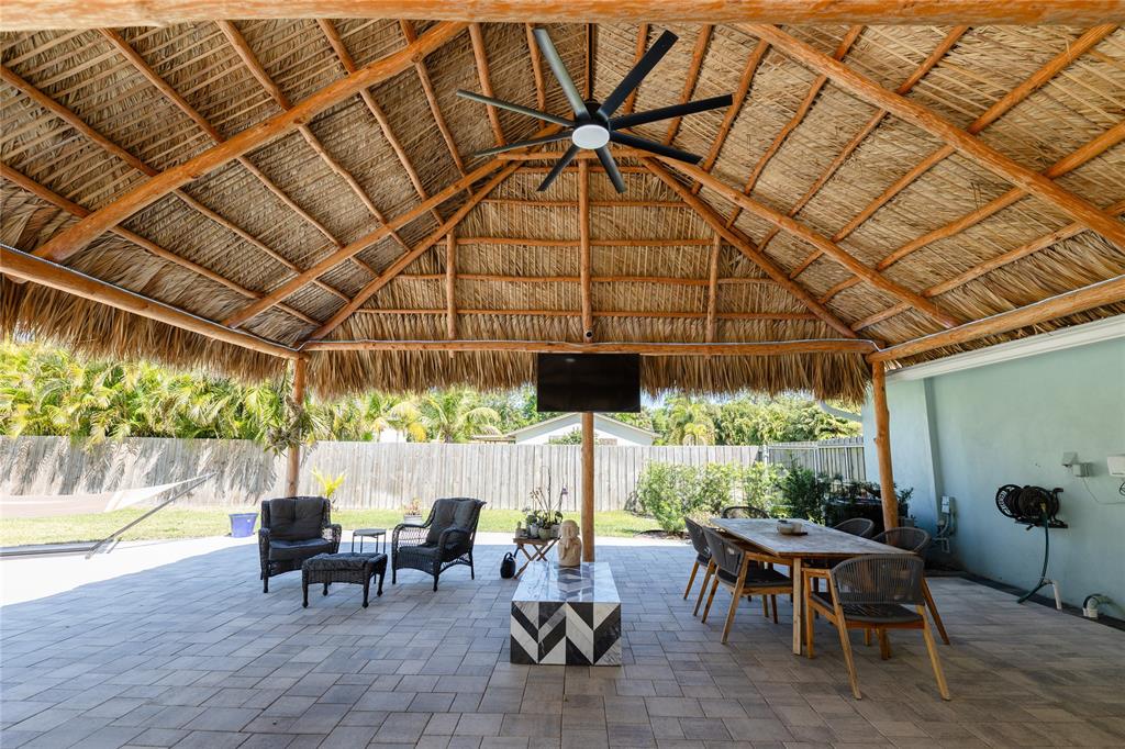 1497 Southwest Buckskin Trail Stuart, FL 34997 - Photo 35 of 48 a view of a patio with table and chairs and potted plants