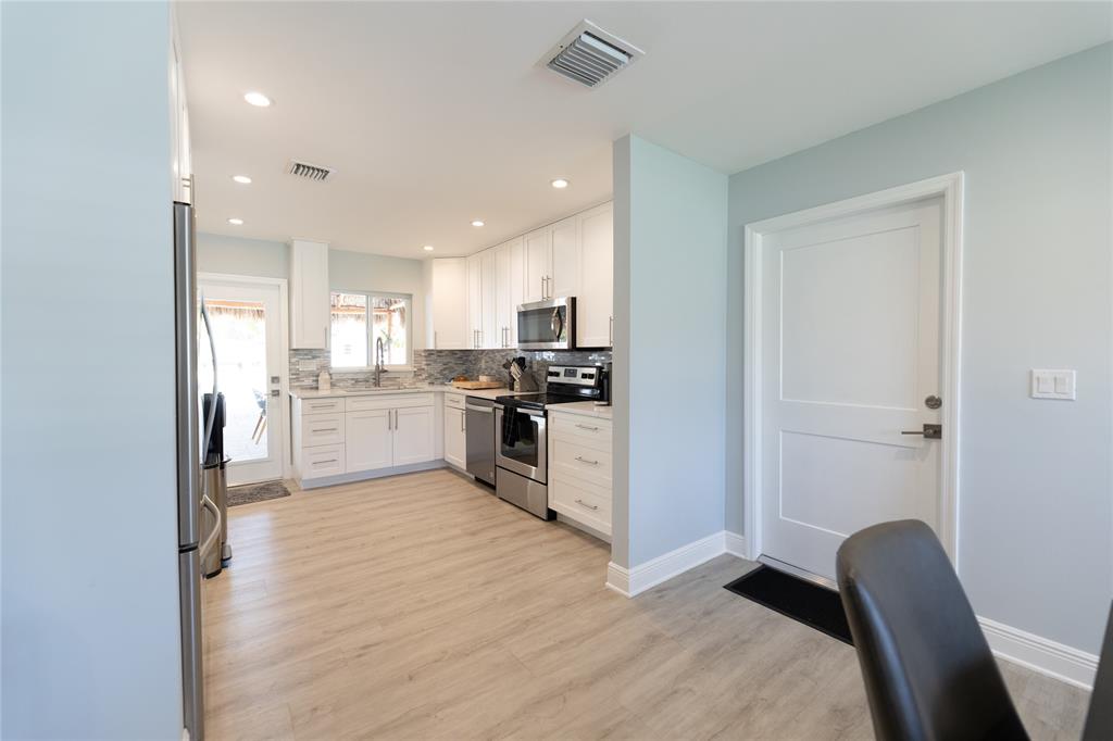 1497 Southwest Buckskin Trail Stuart, FL 34997 - Photo 5 of 48 a kitchen with stainless steel appliances granite countertop a refrigerator sink and cabinets