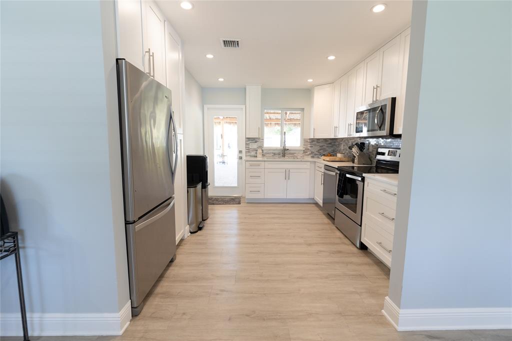 1497 Southwest Buckskin Trail Stuart, FL 34997 - Photo 6 of 48 a large kitchen with cabinets a sink and stainless steel appliances