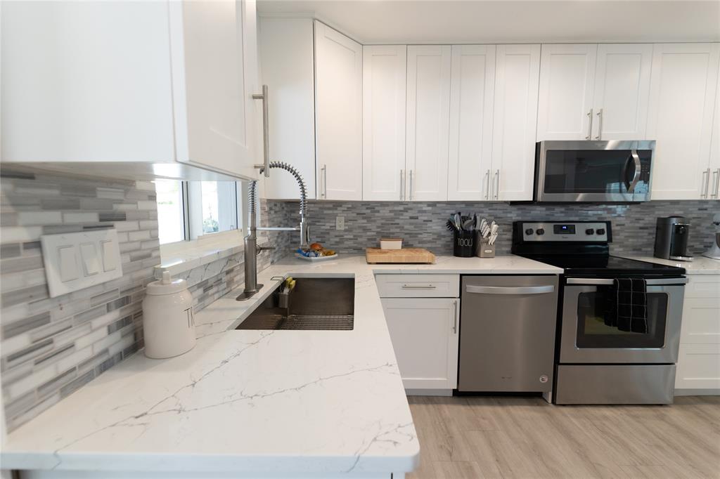 1497 Southwest Buckskin Trail Stuart, FL 34997 - Photo 7 of 48 a kitchen with a stove and a sink