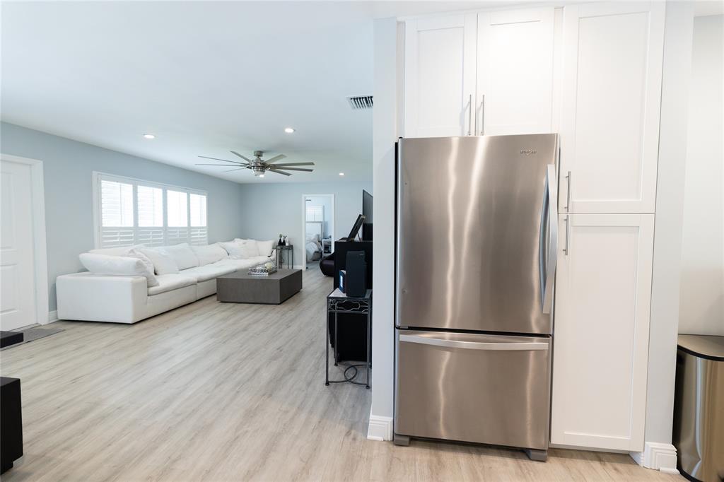 1497 Southwest Buckskin Trail Stuart, FL 34997 - Photo 10 of 48 a refrigerator freezer sitting in a kitchen with white cabinets