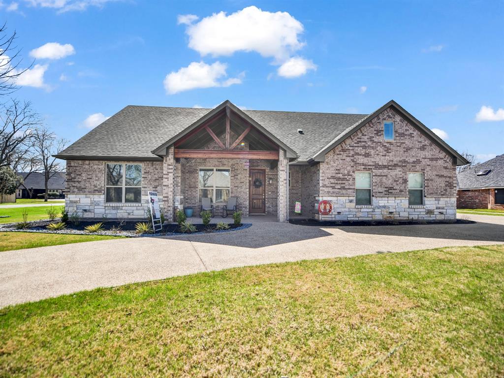 a front view of a house with a garden and yard