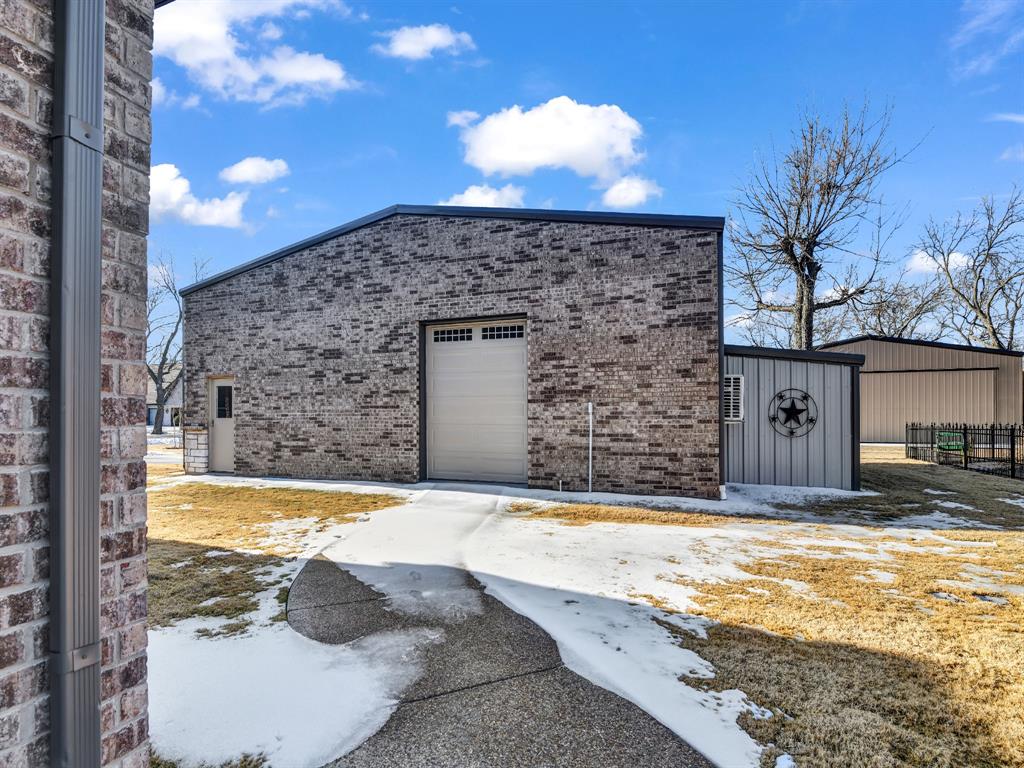 5418 Wedgefield Road Granbury, TX 76049 - Photo 38 of 40 Garage doo on front of hangar and storage shed on right side