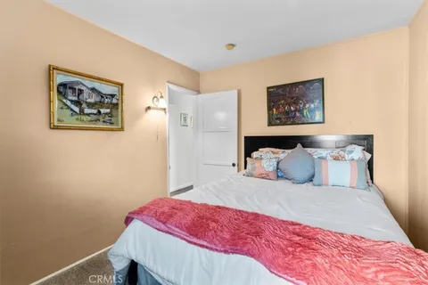 a bedroom with a bed and a wall painting