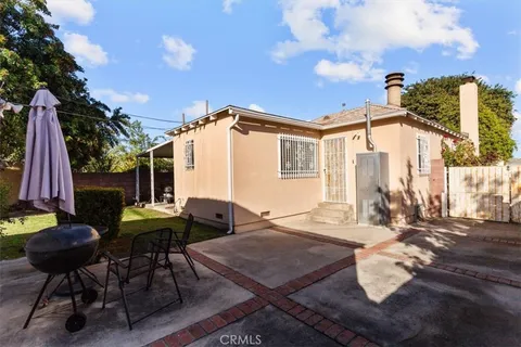 a backyard of a house with table and chairs