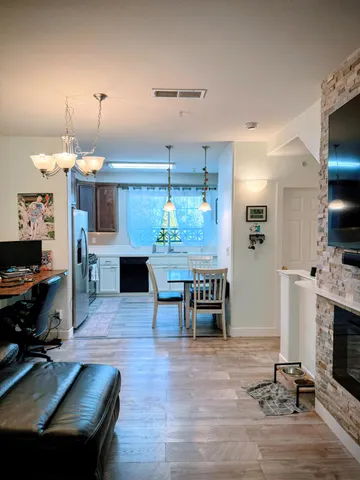 a dining room with furniture a fireplace and a flat screen tv