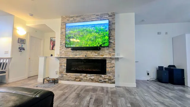 a living room with furniture a flat screen tv and a fireplace