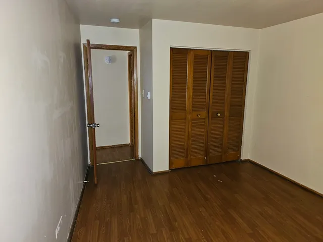 an empty room with wooden floor and a door