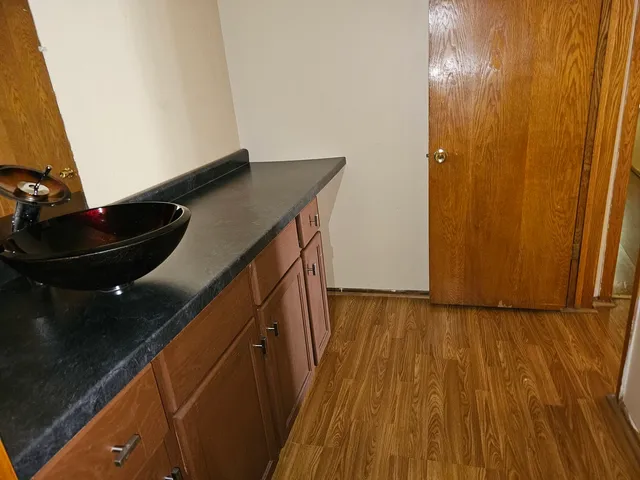 a kitchen with wooden floor and cabinets