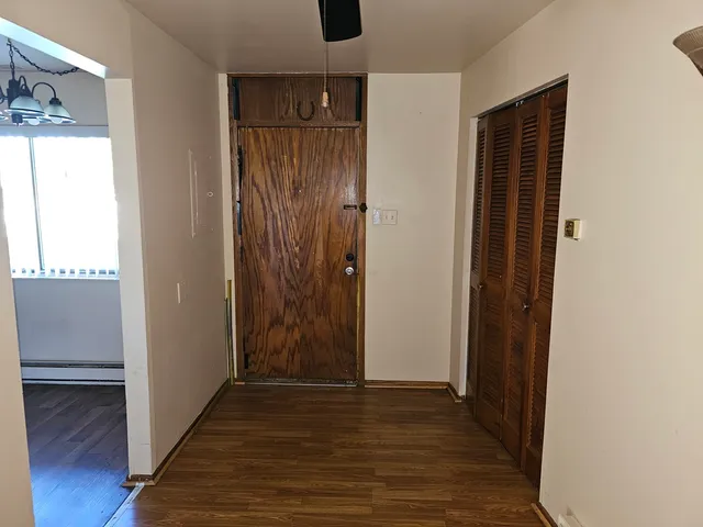 an empty room with wooden floor & windows