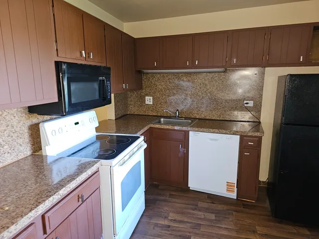 a kitchen with stainless steel appliances granite countertop a sink stove and microwave