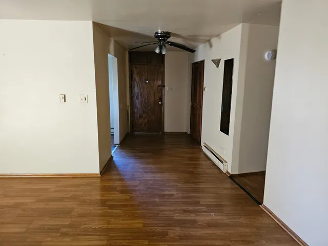 a view of a hallway with wooden floor