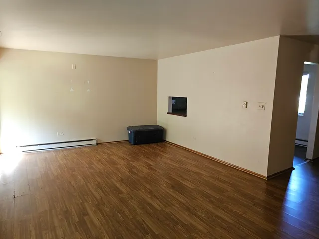 a view of an empty room with wooden floor