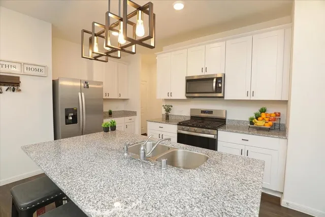 a kitchen with stainless steel appliances granite countertop a sink refrigerator and microwave