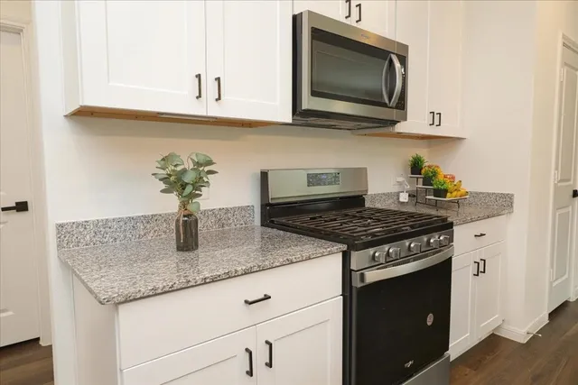a kitchen with stainless steel appliances granite countertop a sink stove and microwave