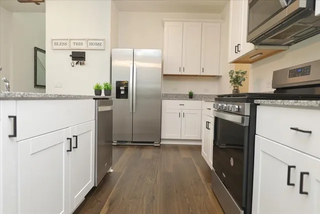 a kitchen with stainless steel appliances a refrigerator sink and white cabinets