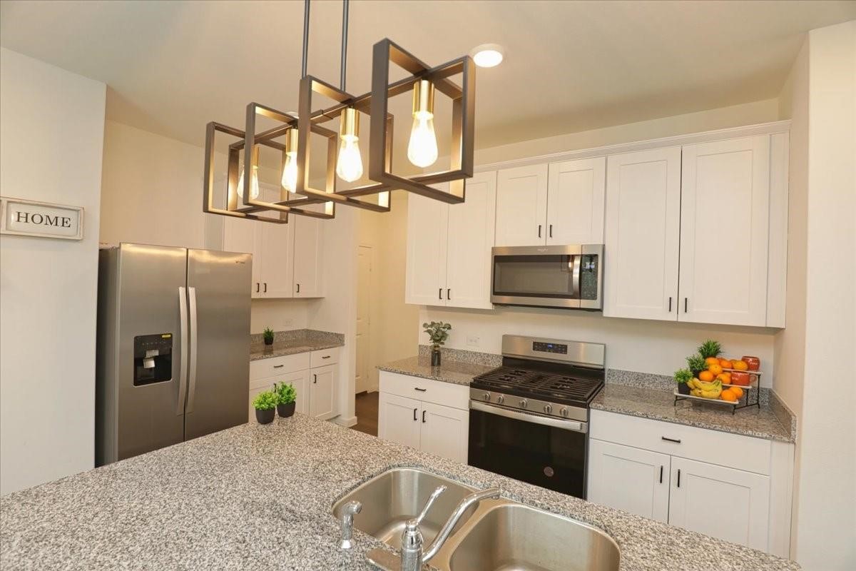 14463 Cedar Br Lane Conroe, TX 77302 - Photo 23 of 50 a kitchen with stainless steel appliances granite countertop a refrigerator a stove and a sink