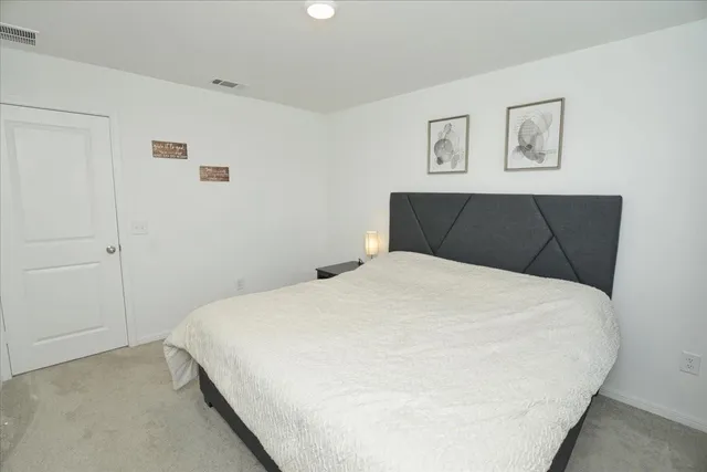 a bedroom with a bed and painting on the wall