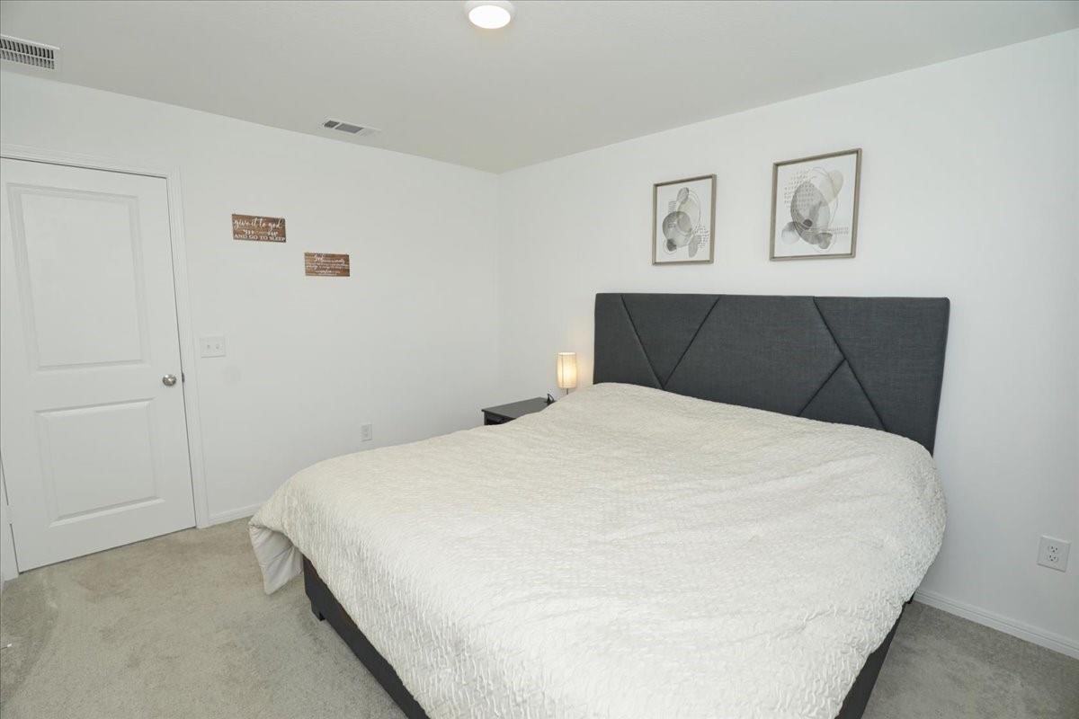 14463 Cedar Br Lane Conroe, TX 77302 - Photo 26 of 50 a bedroom with a bed and painting on the wall