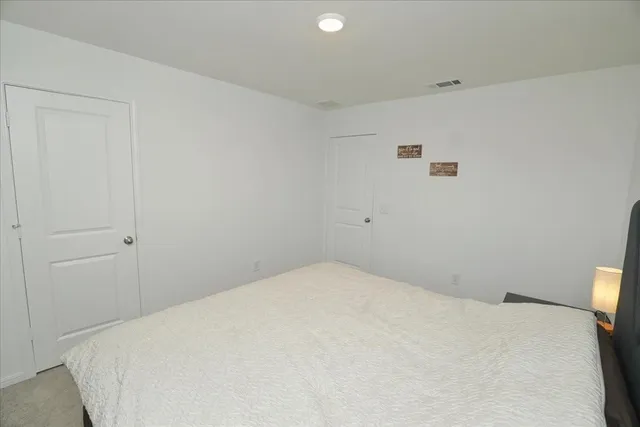 a bedroom with a bed and a white wall