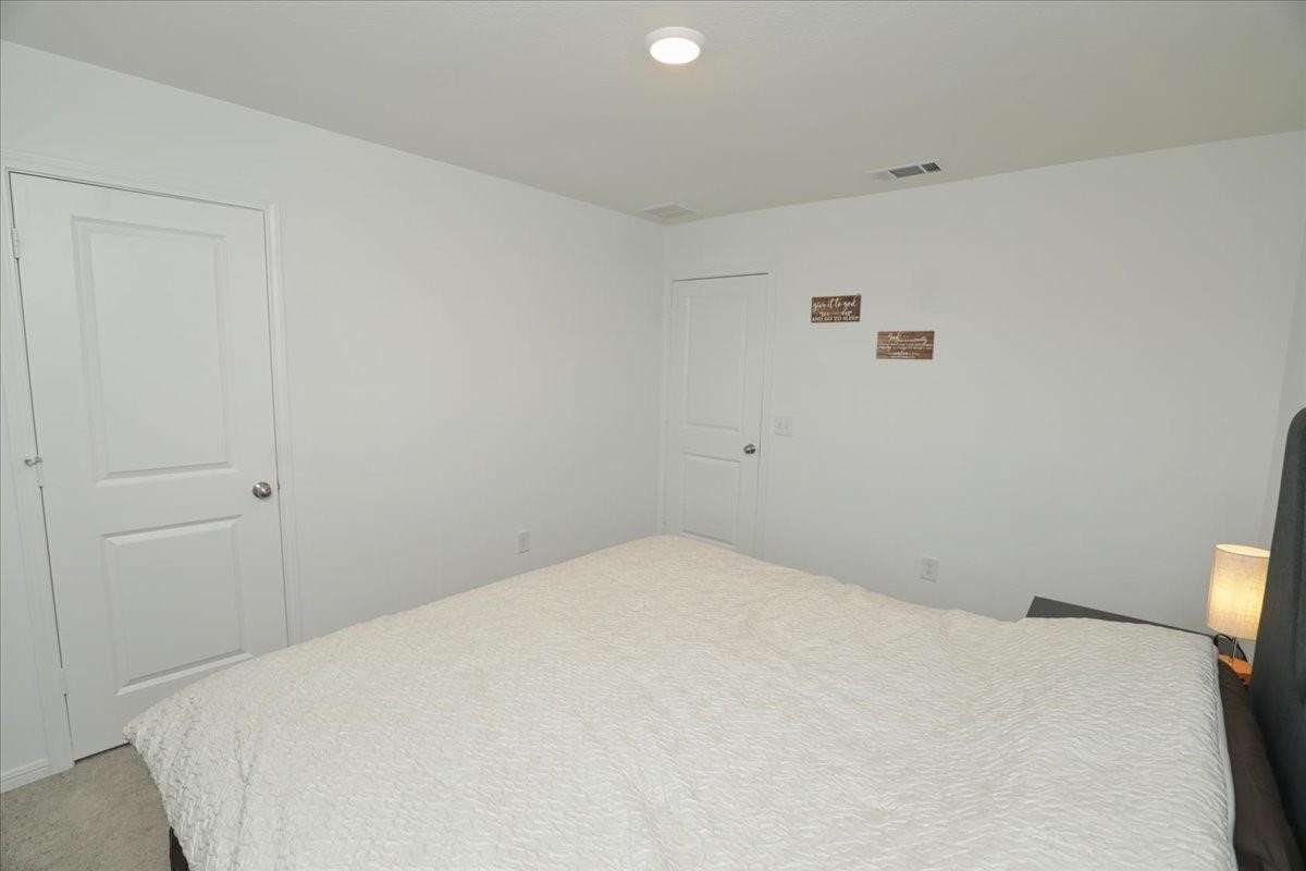 14463 Cedar Br Lane Conroe, TX 77302 - Photo 27 of 50 a bedroom with a bed and a white wall