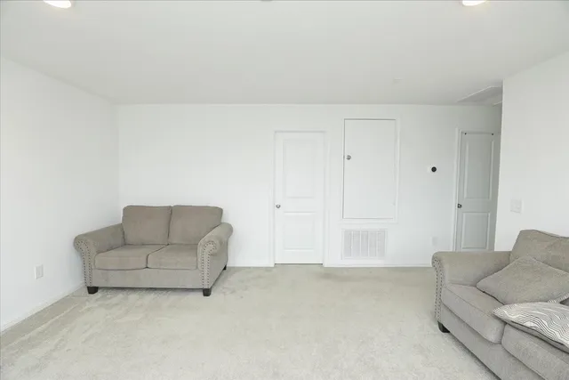 a living room with furniture and white walls