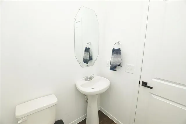 a bathroom with a sink a toilet and mirror