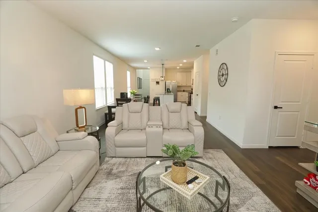 a living room with furniture and a wooden floor