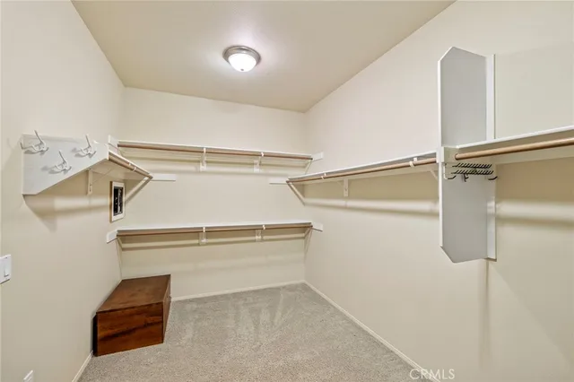 a bedroom with a bed and a lamp on dresser