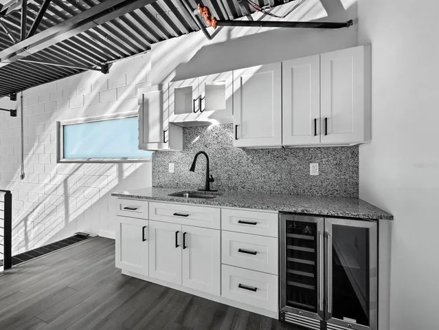 a kitchen with granite countertop a sink and cabinets