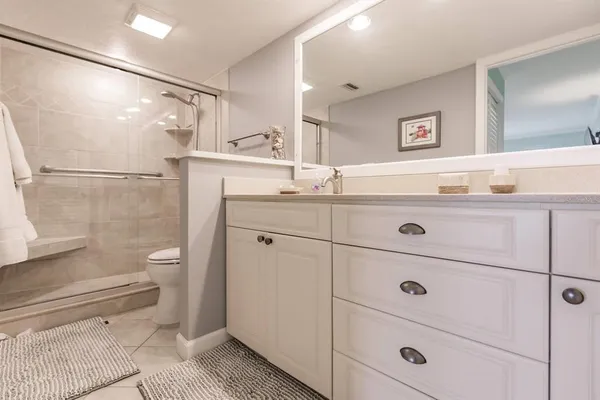 a bathroom with a sink a toilet and shower