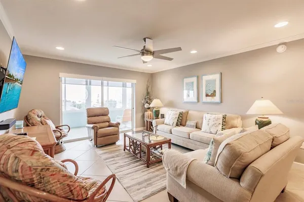 a living room with furniture ceiling fan and a window