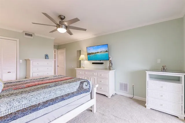 a bedroom with a bed and a chandelier fan