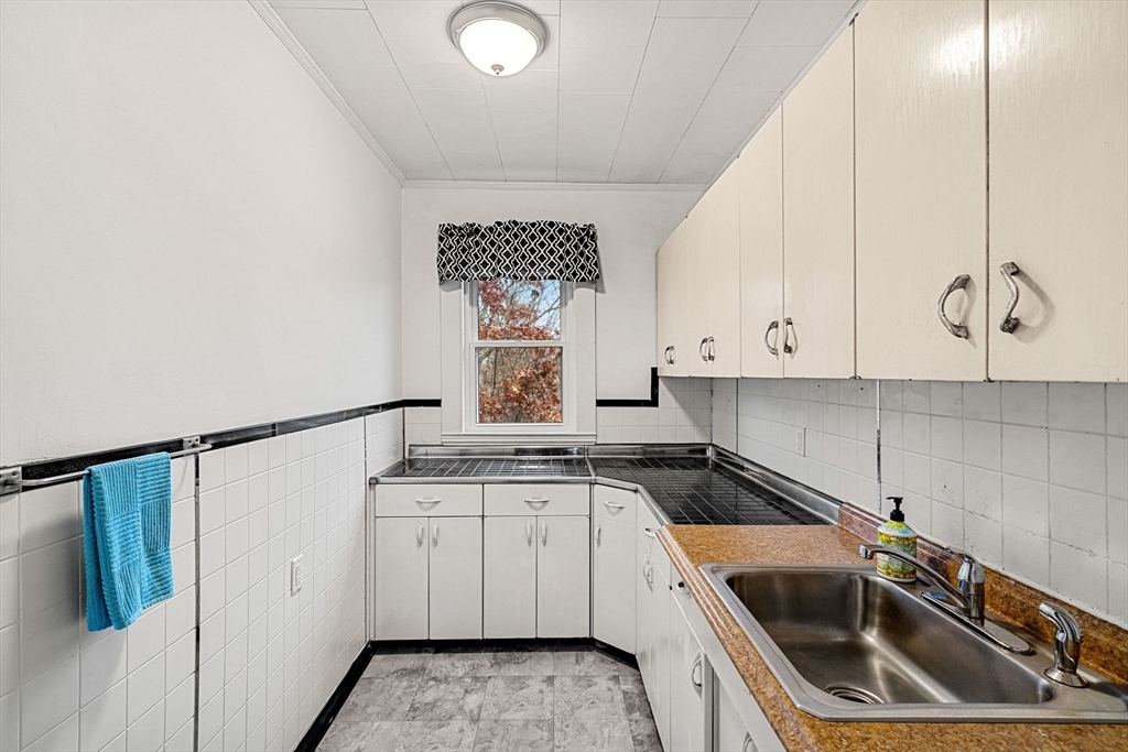 11 Devonshire Street Lawrence, MA 01843 - Photo 14 of 41 a kitchen with a sink a stove and cabinets