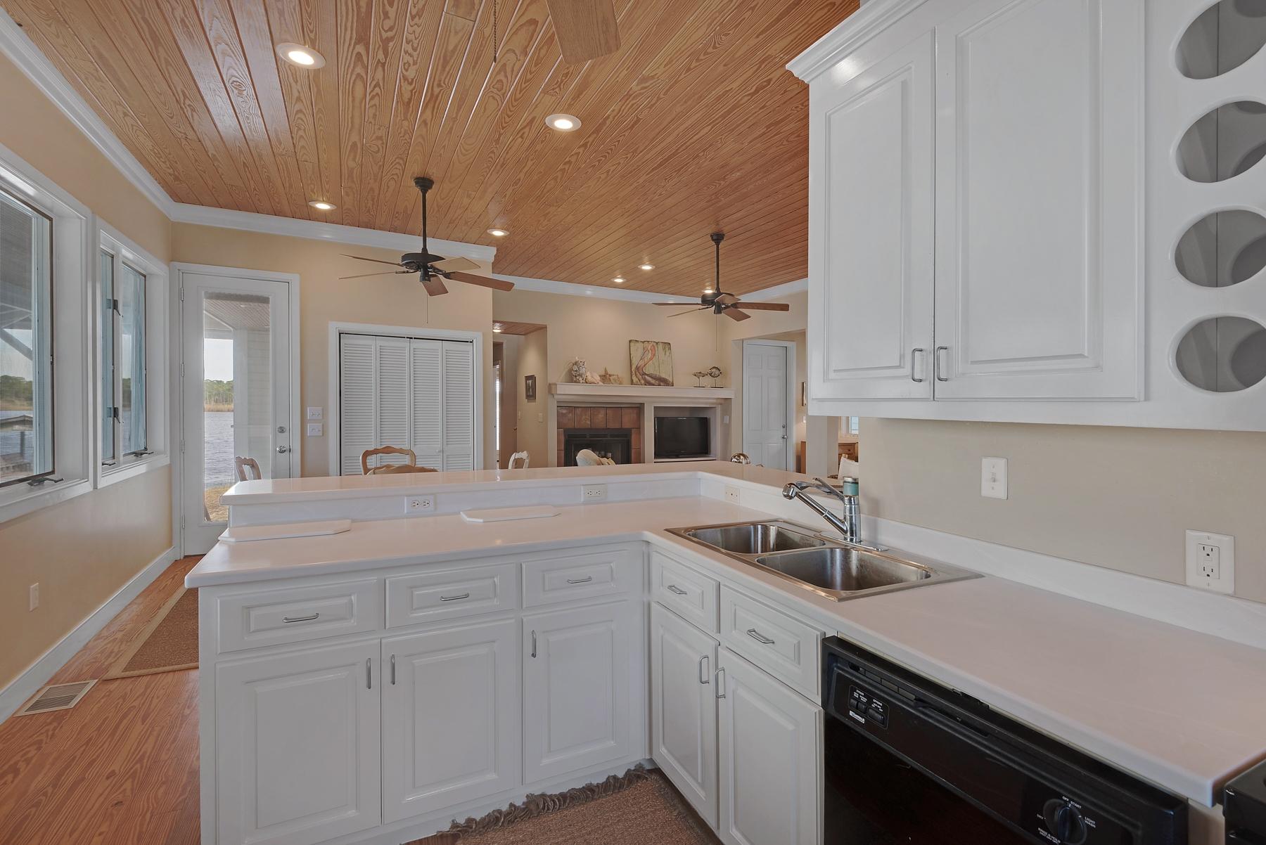 139 Banfill Road Santa Rosa Beach, FL 32459 - Photo 20 of 46 a kitchen with a sink dishwasher and white cabinets with wooden floor