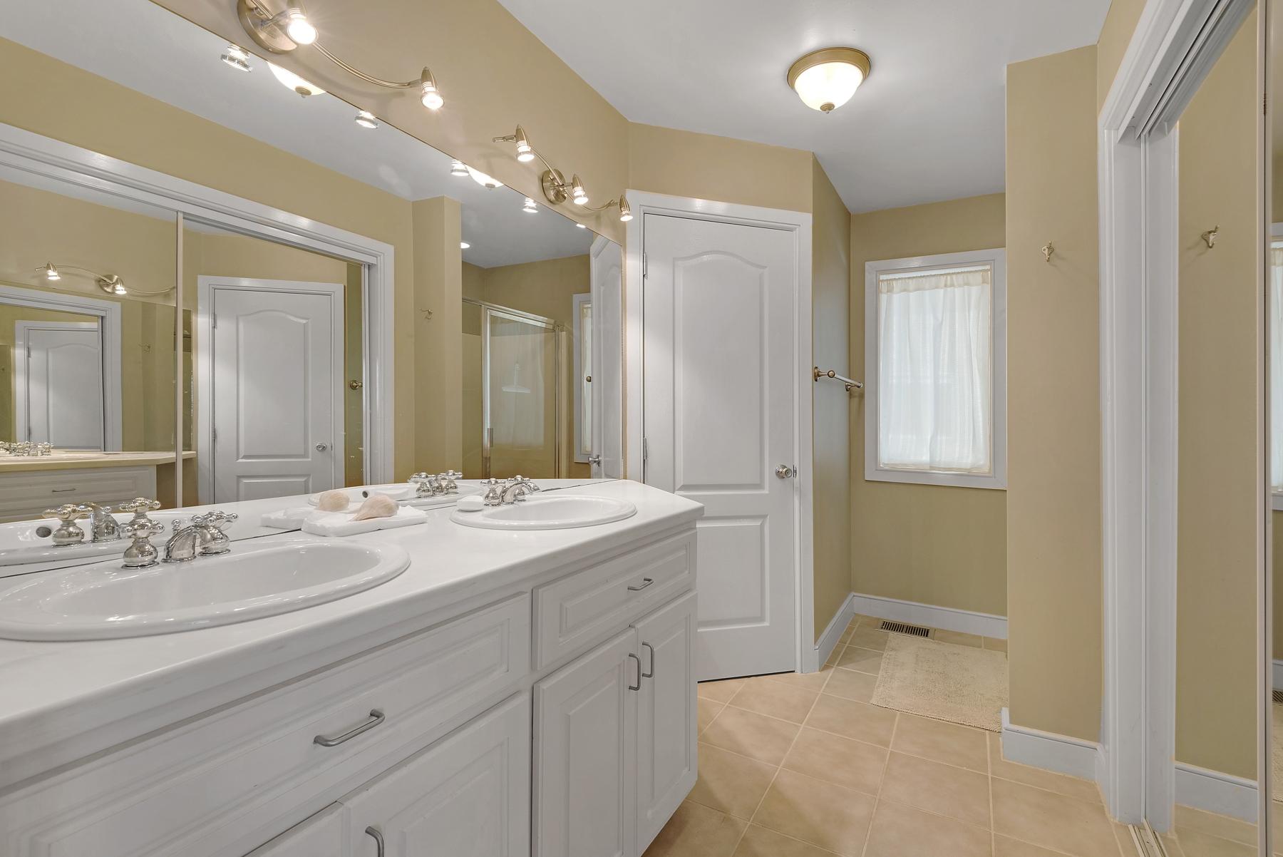 139 Banfill Road Santa Rosa Beach, FL 32459 - Photo 25 of 46 a spacious bathroom with a granite countertop sink a mirror and a