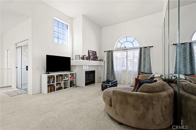 a living room with furniture a flat screen tv and a large window