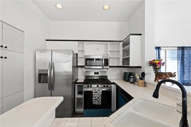 a kitchen with stainless steel appliances a refrigerator and a stove top oven