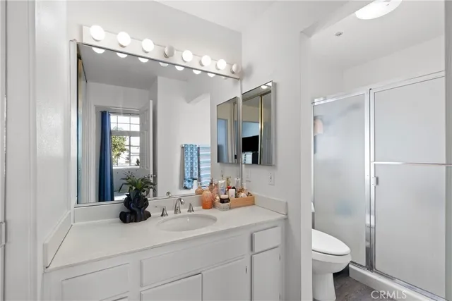 a bathroom with a sink a toilet and shower a mirror