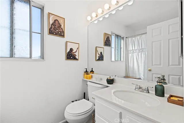 a bathroom with a sink vanity mirror and toilet